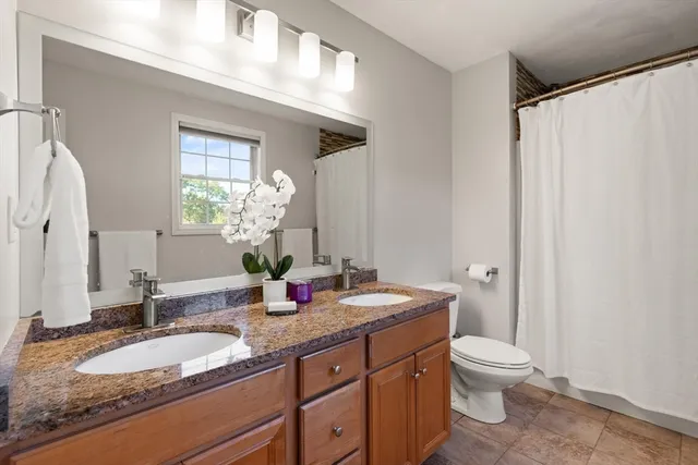 a bathroom with a granite countertop sink toilet and shower