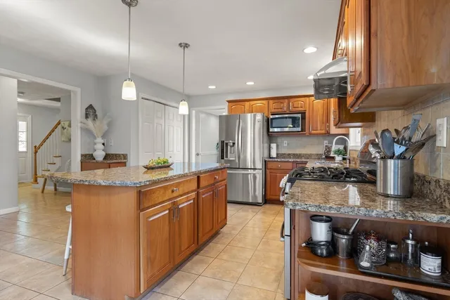 a kitchen with stainless steel appliances granite countertop a stove a sink and a refrigerator