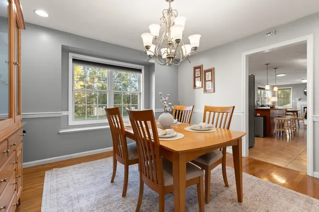 a view of a dining room with furniture a chandelier and wooden floor