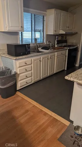 a kitchen with granite countertop a sink and a stove