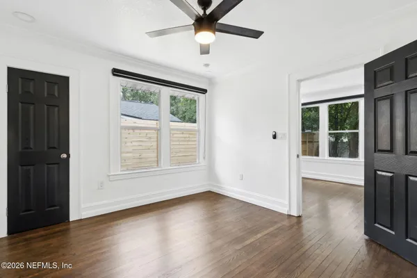 an empty room with wooden floor and windows