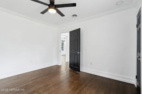 a view of a room with wooden floor and white walls