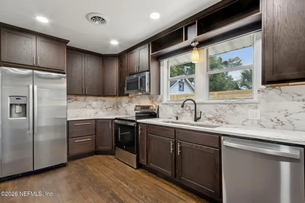 a kitchen with a sink stainless steel appliances and cabinets