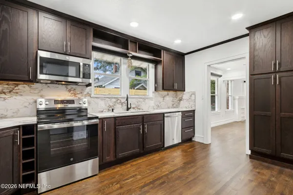 a kitchen with stainless steel appliances kitchen island granite countertop a stove and a sink