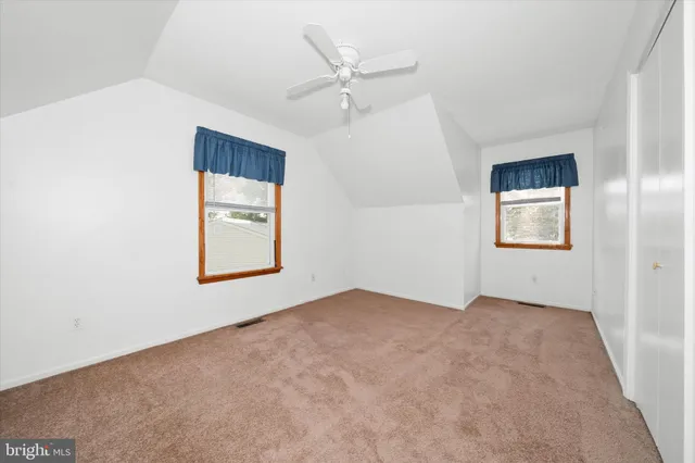 an empty room with windows and closet