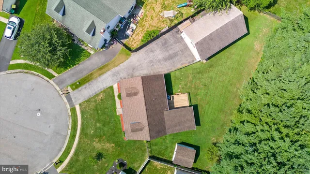 an aerial view of a house with a yard and a large tree
