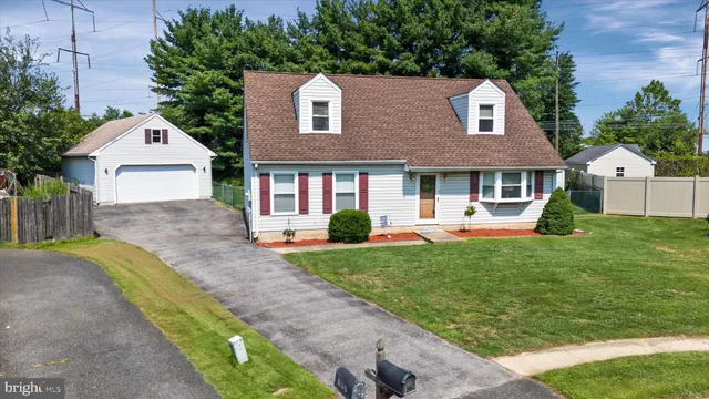 a front view of a house with a yard and trees