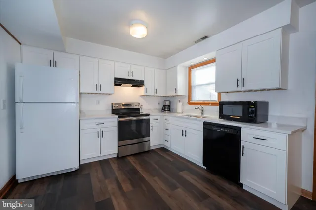 a kitchen with granite countertop white cabinets and white appliances