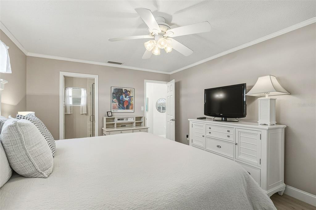 6300 Midnight Pass Road, Unit 21 Sarasota, FL 34242 - Photo 18 of 30 a bedroom with a large bed and a flat screen tv