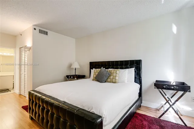 a bedroom with a bed and a mirror on dresser