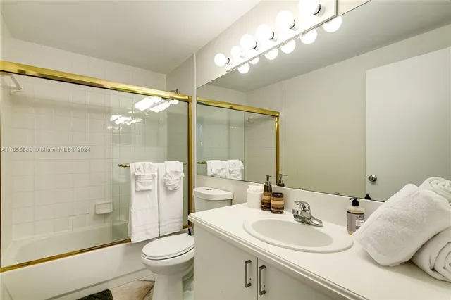 a bedroom with a bed and dresser with mirror