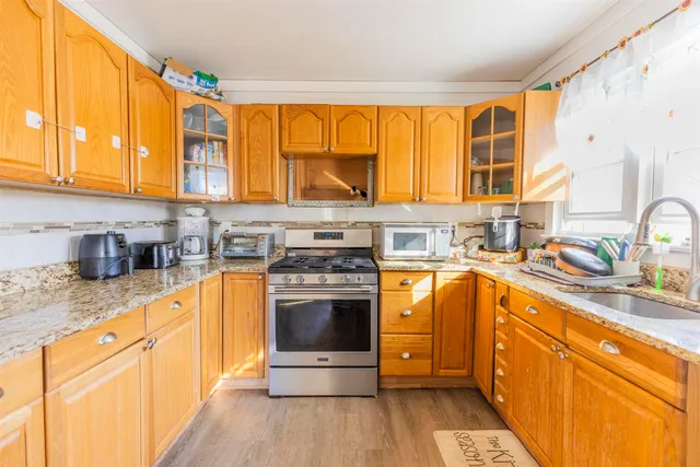 a kitchen with stainless steel appliances granite countertop a sink stove and cabinets