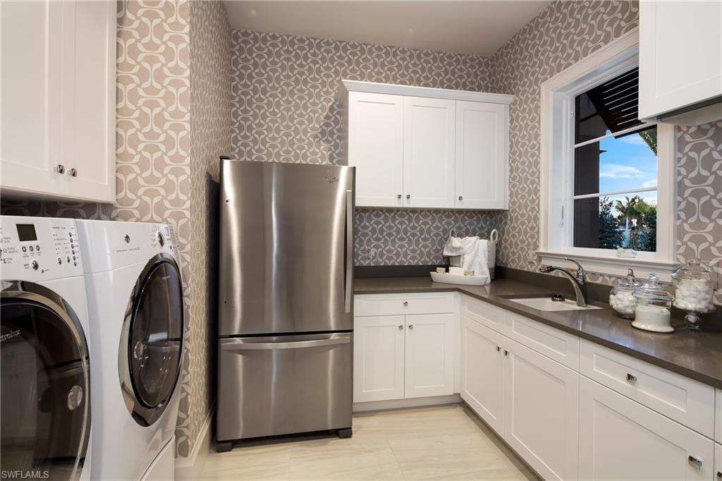 6818 Mangrove Avenue Naples, FL 34109 - Photo 11 of 24 a kitchen with stainless steel appliances a refrigerator sink and cabinets