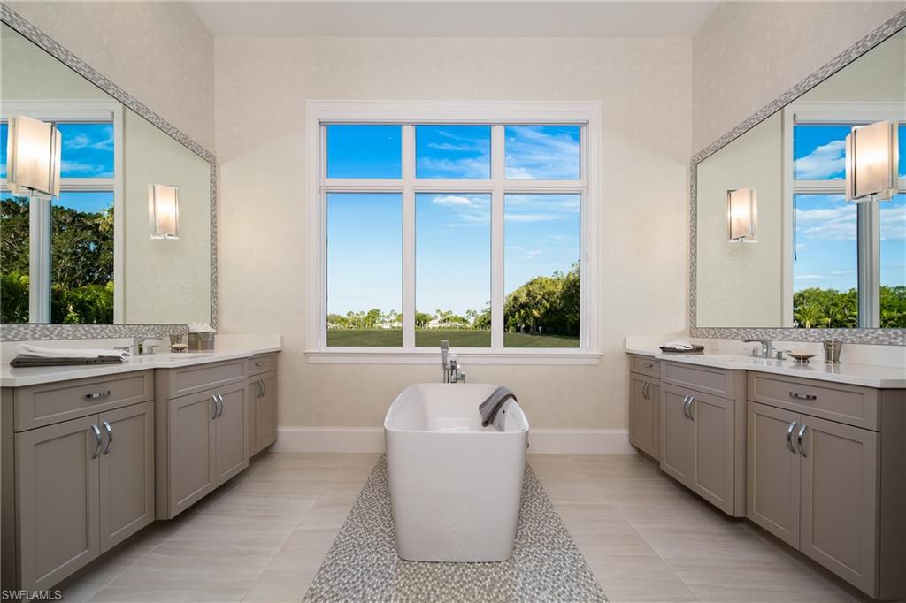 6818 Mangrove Avenue Naples, FL 34109 - Photo 13 of 24 a bathroom with a double vanity sink a large mirror and a bathtub