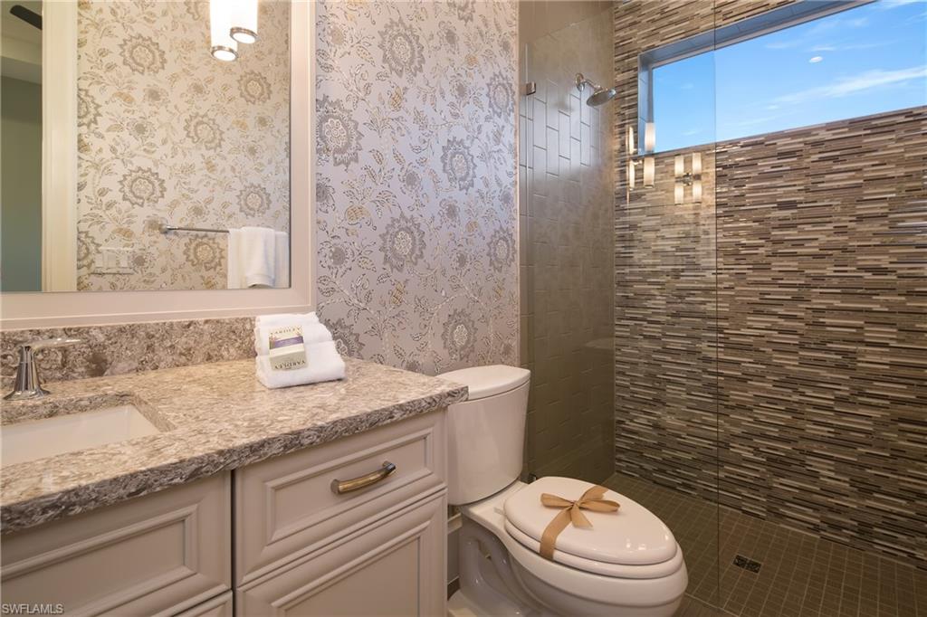6818 Mangrove Avenue Naples, FL 34109 - Photo 6 of 24 a bathroom with a granite countertop toilet sink and mirror
