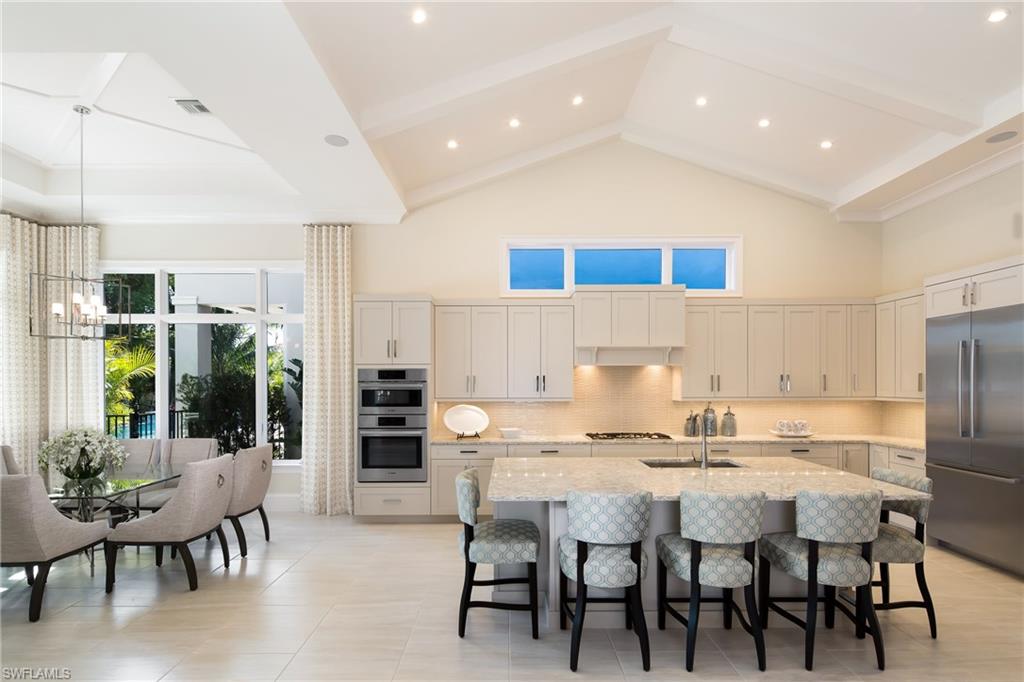 6818 Mangrove Avenue Naples, FL 34109 - Photo 9 of 24 a kitchen with a dining table chairs and refrigerator
