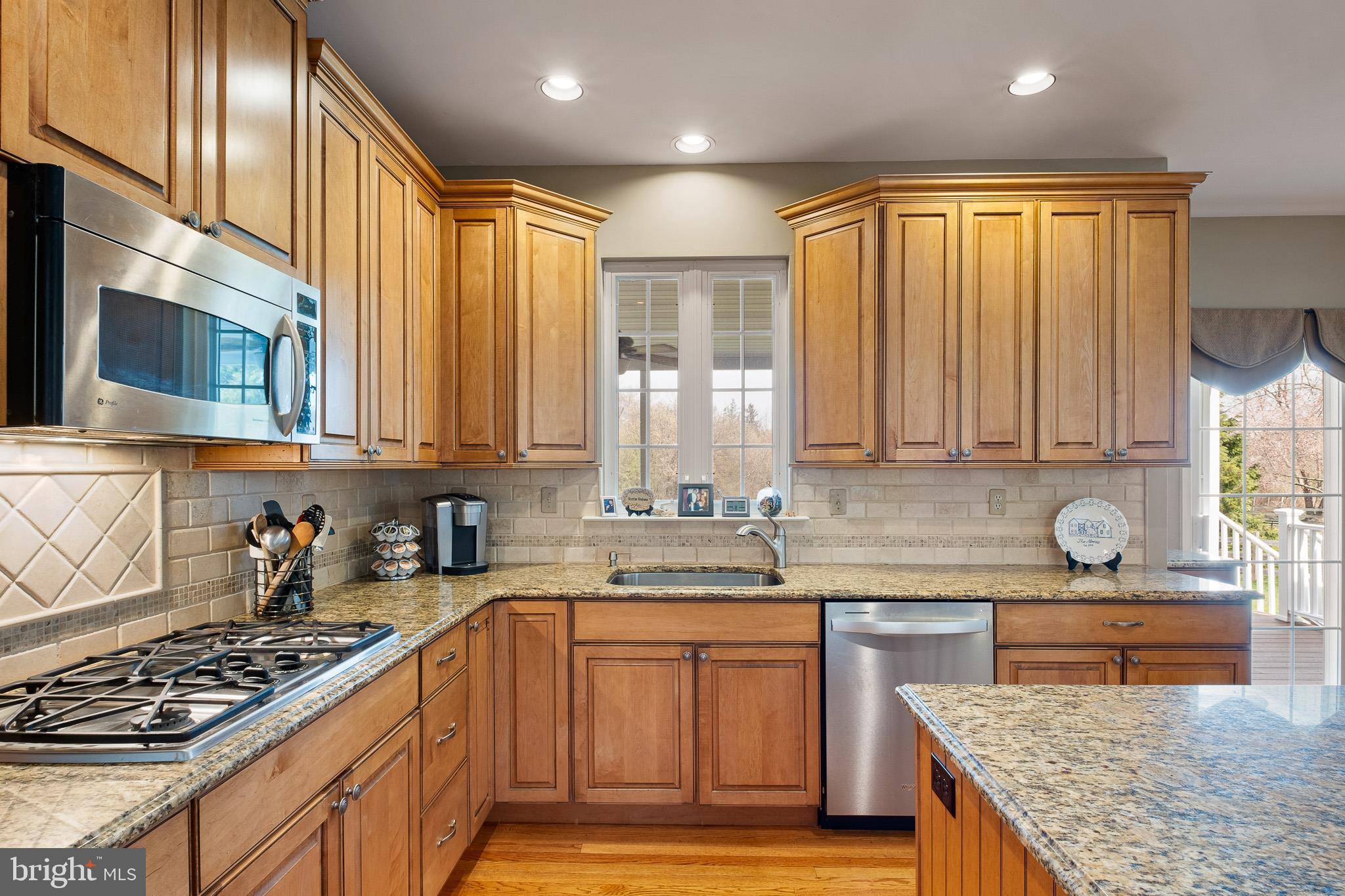 26 Woodside Farm Road Garnet Valley, PA 19060 - Photo 36 of 57 a kitchen with stainless steel appliances granite countertop a stove a sink dishwasher and cabinets with wooden floor