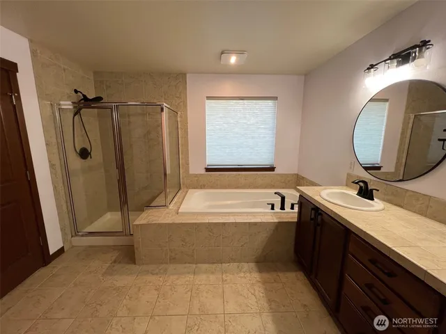 a bathroom with a tub sink and mirror