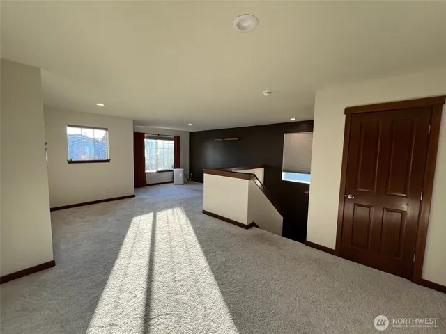 a view of a refrigerator in kitchen and an empty room