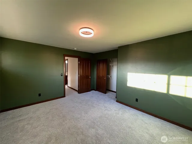 an empty room with closet and windows