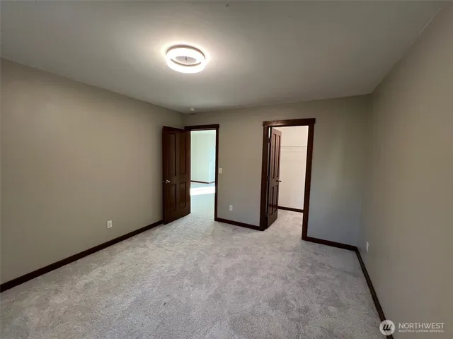 an empty room with closet and mirror