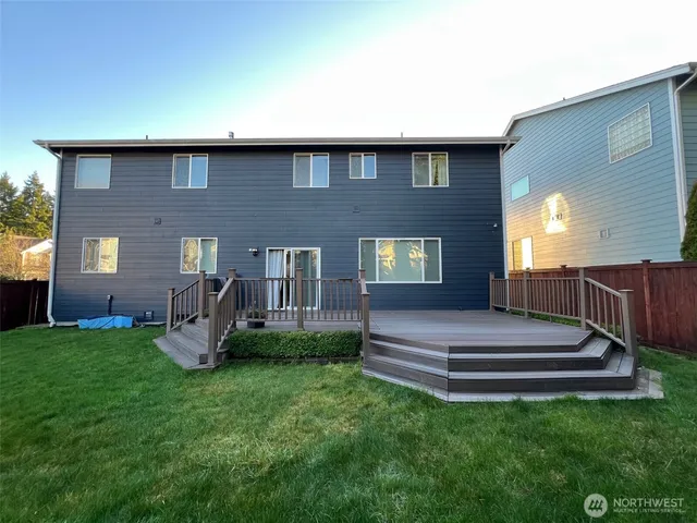 a front view of a house with garden and trees