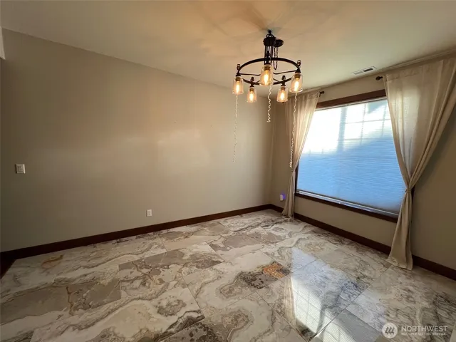 a view of a livingroom with a chandelier fan and wooden floor