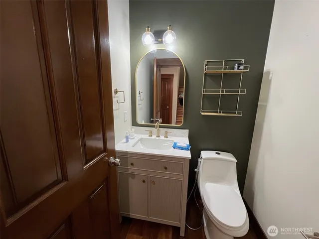 a bathroom with a toilet sink and mirror