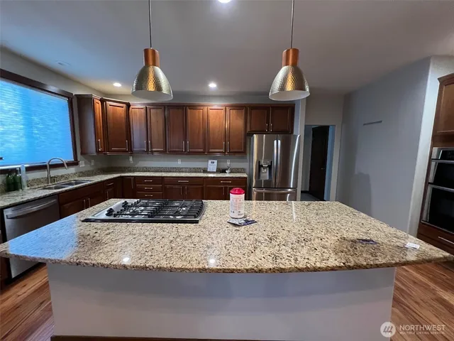 a kitchen with kitchen island granite countertop wooden cabinets granite counter tops and a stove