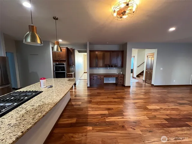 a large kitchen with kitchen island a stove a sink dishwasher and a flat screen tv