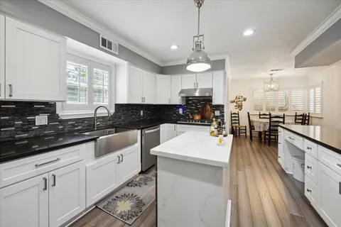 a large white kitchen with lots of counter space white cabinets and stainless steel appliances