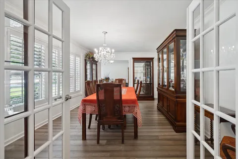 a dining room with furniture a chandelier and wooden floor