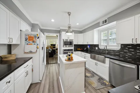 a kitchen with granite countertop lots of counter top space and appliances