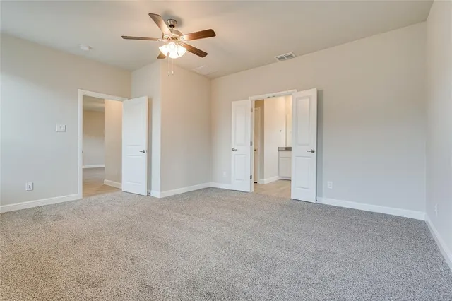 a view of an empty room with a ceiling fan