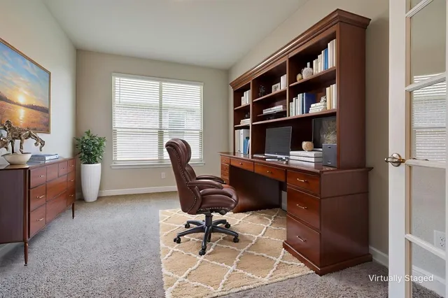 a view of a workspace with furniture and a window