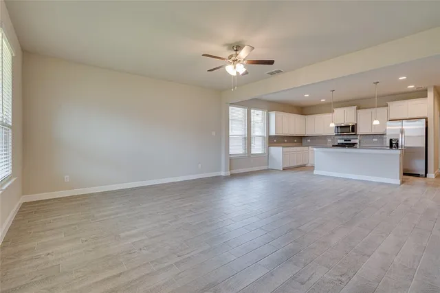 a view of a kitchen with a sink a ceiling fan and refrigerator