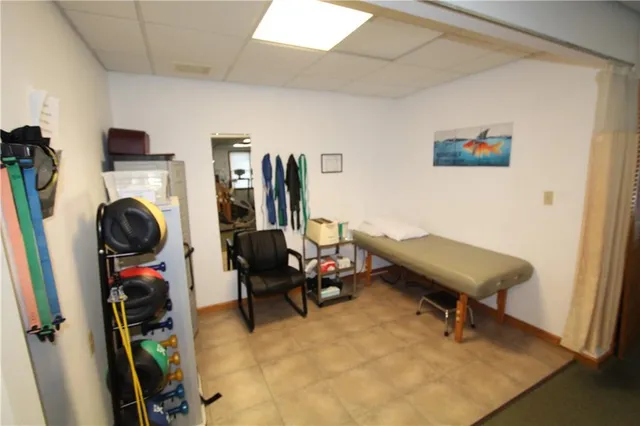 a living room with furniture and a gym machine