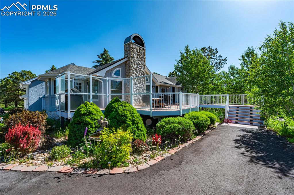 17815 Saddlewood Road Monument, CO 80132 - Photo 1 of 41 Beautifully landscaped front elevation with mature trees and inviting curb appeal.