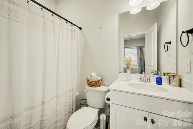 a bathroom with a sink vanity mirror and toilet
