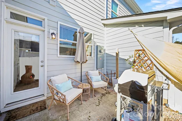 a view of a patio with couple of chairs and a fire pit