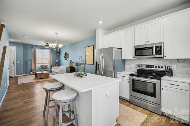a kitchen with sink a refrigerator and chairs