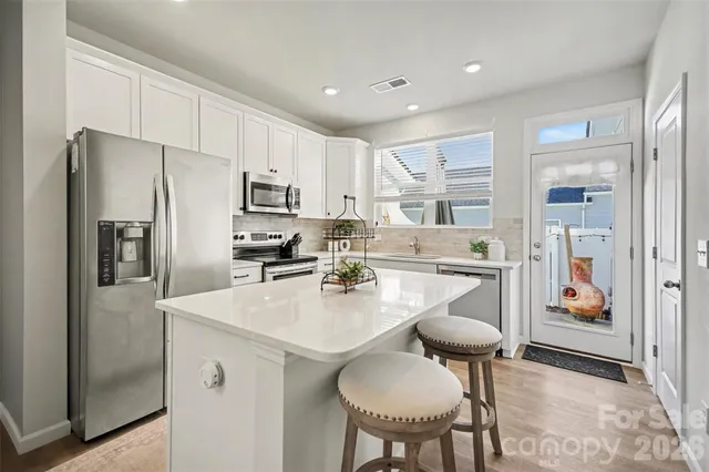 a kitchen with refrigerator cabinets dining table and chairs