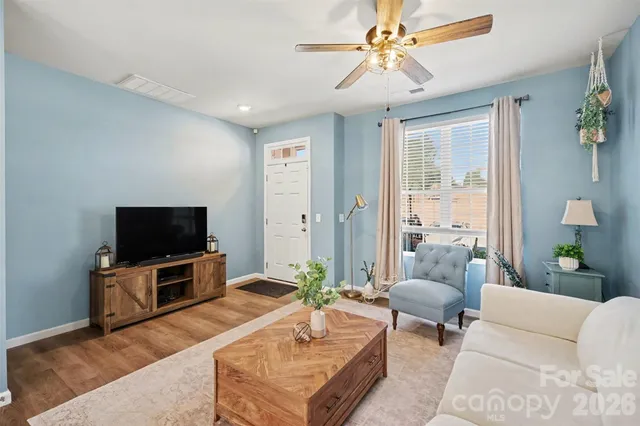 a living room with furniture a flat screen tv and a large window