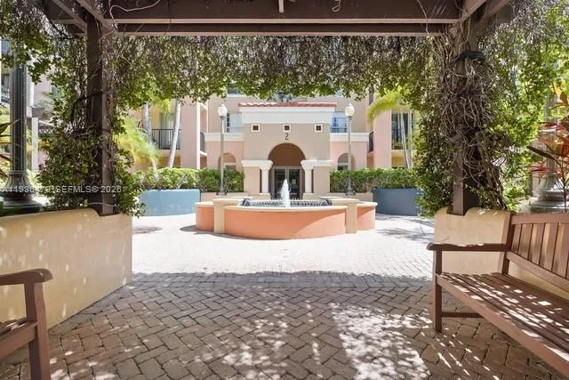 a view of a fountain with a bench in patio