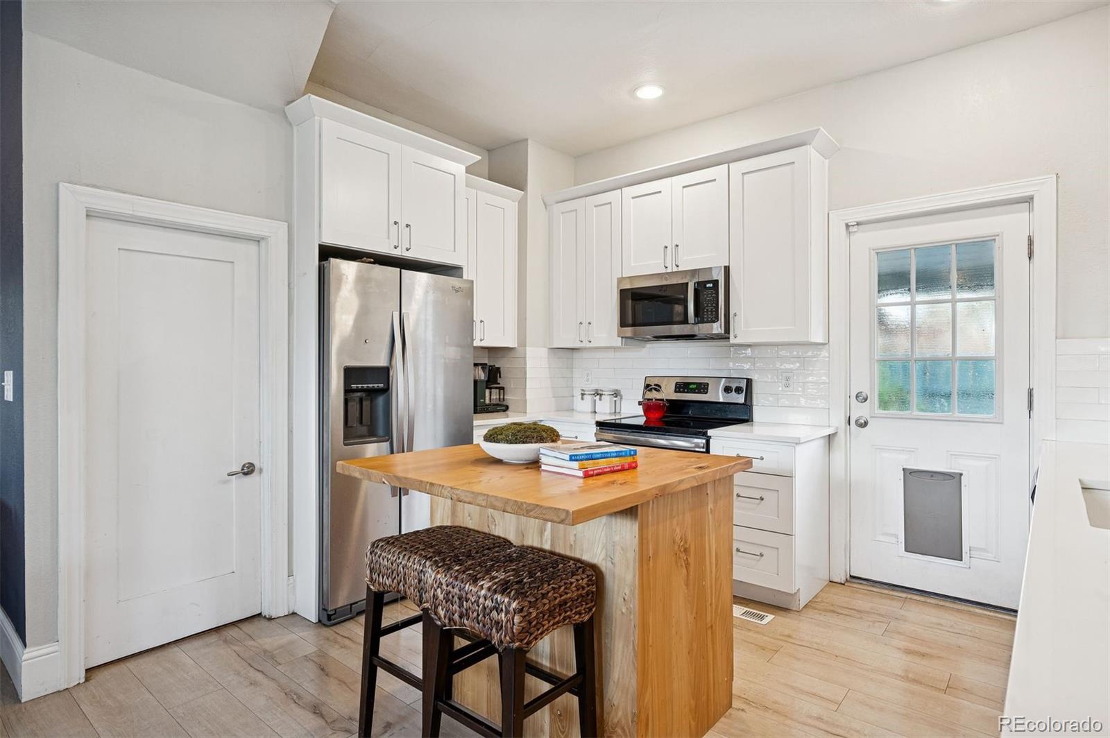 2109 West 41st Avenue Denver, CO 80211 - Photo 8 of 33 a kitchen with stainless steel appliances granite countertop a stove top oven a refrigerator a sink and dishwasher with wooden floor