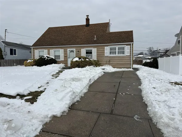 a front view of a house with a yard covered in snow