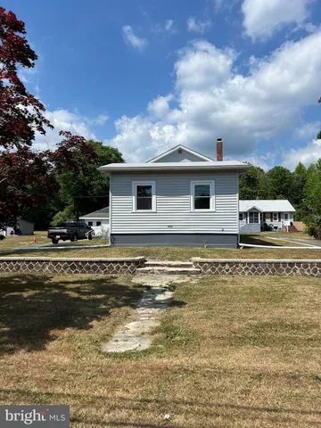 a view of a house with pool and mountains in the background