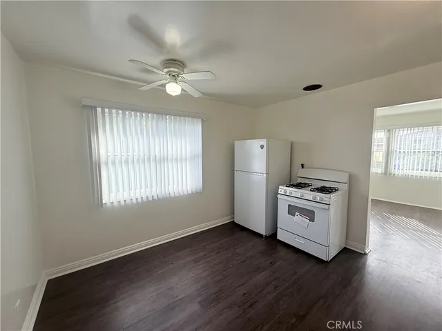 a kitchen with granite countertop a stove and a white cabinets