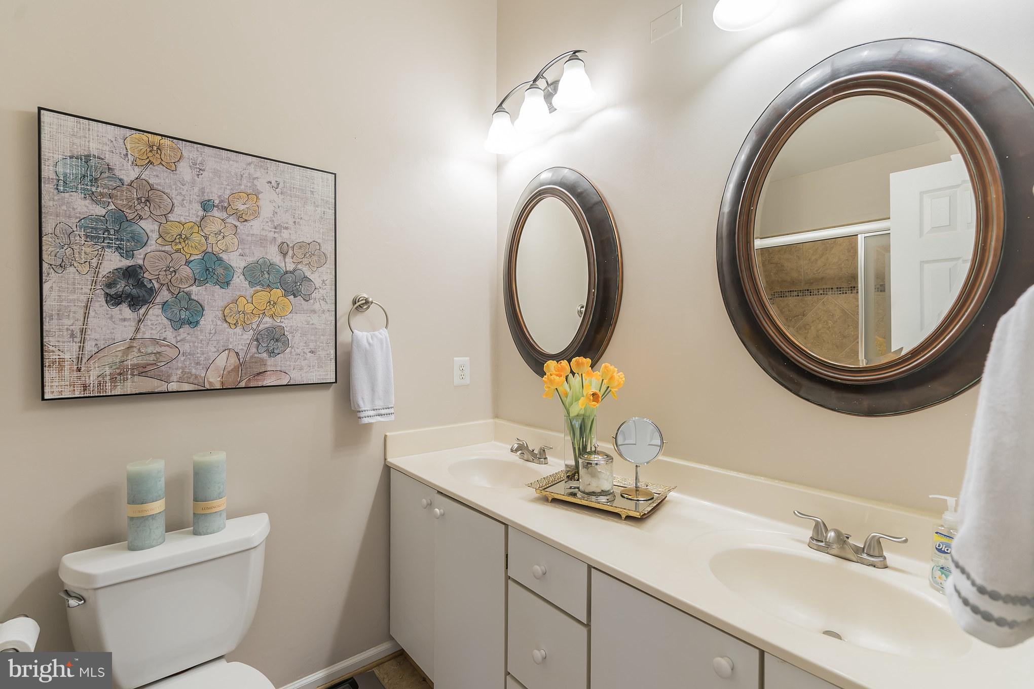11459 Heritage Commons Way Reston, VA 20194 - Photo 23 of 30 a bathroom with a toilet a sink and a mirror
