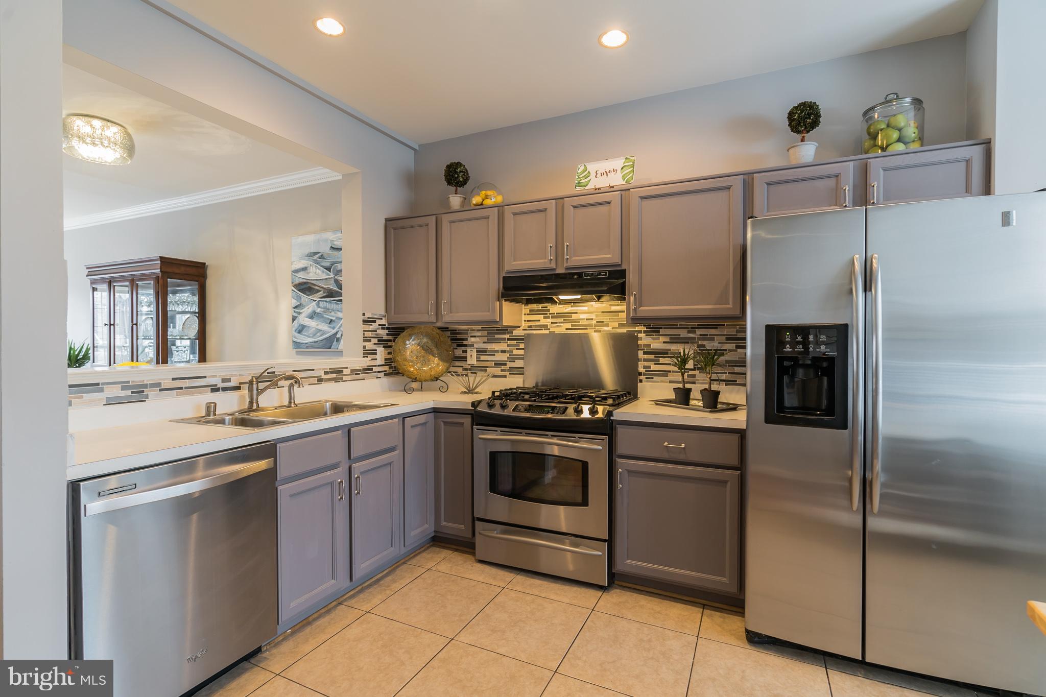 11459 Heritage Commons Way Reston, VA 20194 - Photo 8 of 30 a kitchen with a sink stainless steel appliances and cabinets
